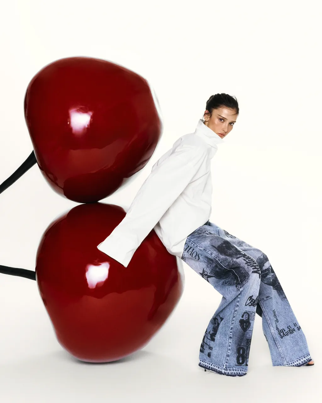 Modelo Colcci sentada sobre cerejas gigantes